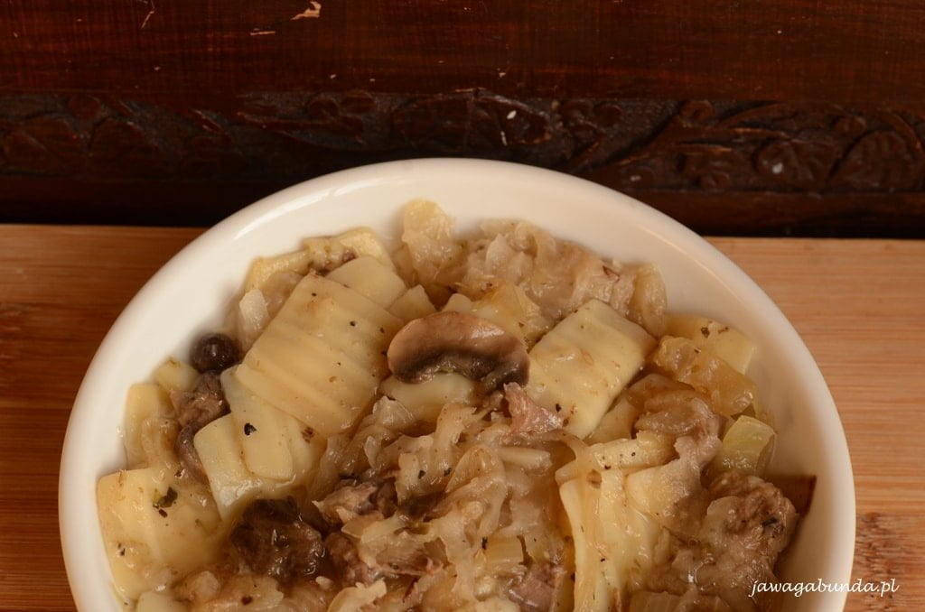 Łazanki podane w misce, pełnej kapusty kiszonej i treściwych kawałków mięsa i kiełbasy