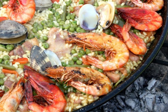 Paella przygotowana z owocami morza i pomidorami. Przygotowana na specjalnej patelni.
