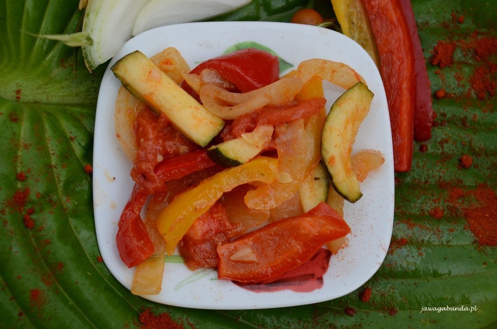 Leczo z papryką, cukinia i pomidorami podane na talerzu.