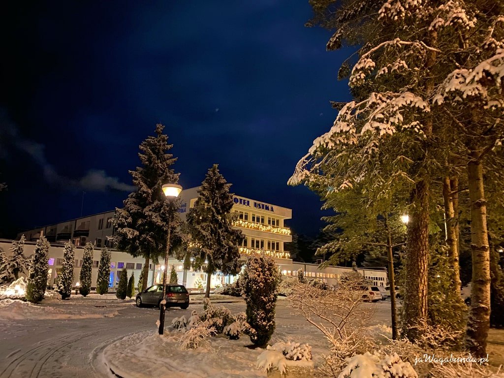budynek hotelu oświetlony nocą i zasypany śniegiem