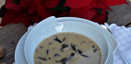 Zabielana zupa grzybowa na wigilijny stół. Grzybowa podana z makaronem w białym talerzu.