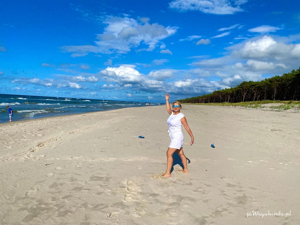 kobieta w białej odzieży na plaży nad morzem