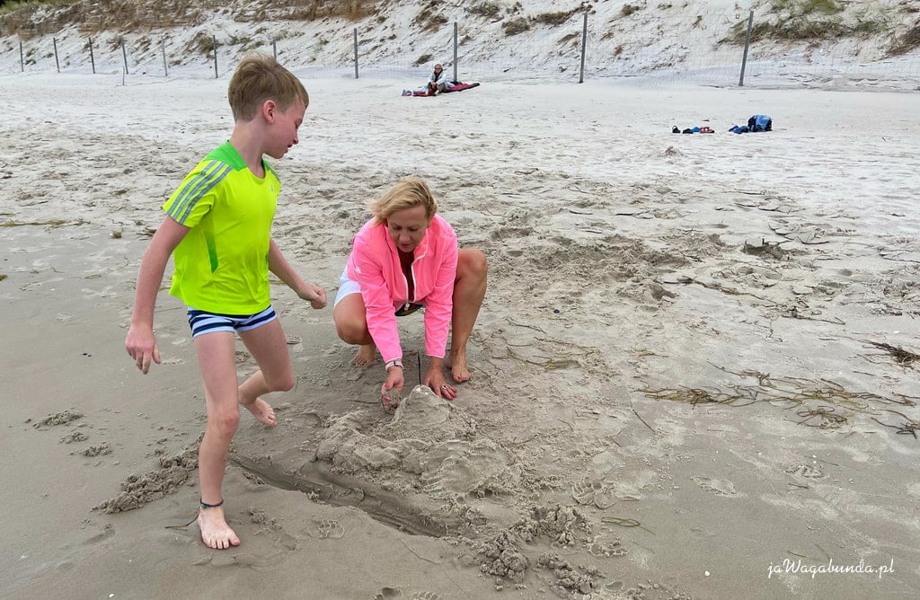 dziecko i kobieta bawią się w piasku na plaży