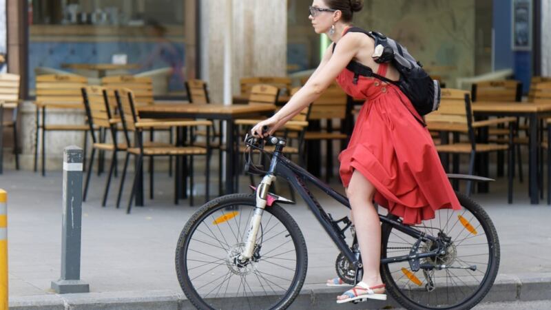 kobieta w czerwonej suki jedzie na rowerze na plecach ma plecak