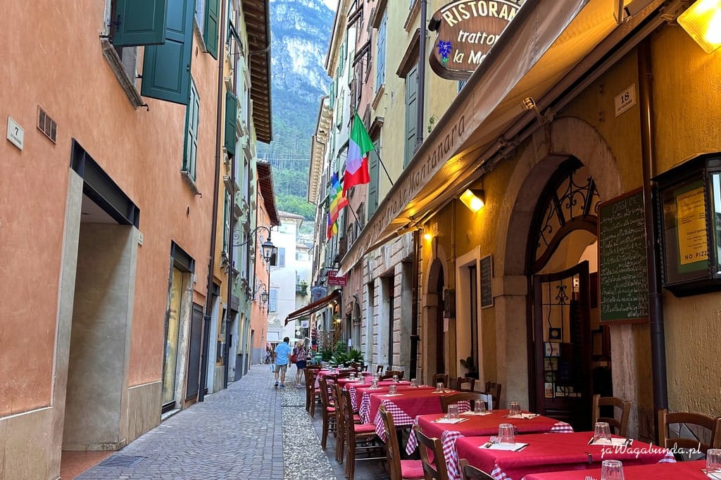 wąska uliczka w starym mieście a w niej nakryte stoliki w restauracji