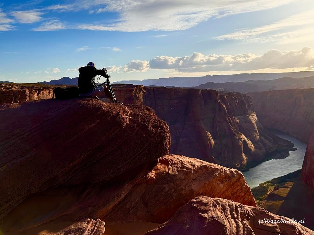 mężczyzna na skałach nad przepaścią robi zdjęcia