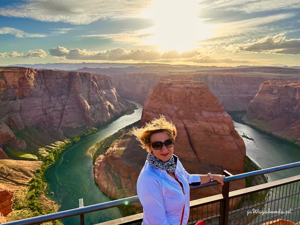 kobieta stoi przy barierce w pobliżu zakole rzeki w dole